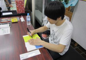 本にイラストとサインを入れている大橋裕之さんです。
