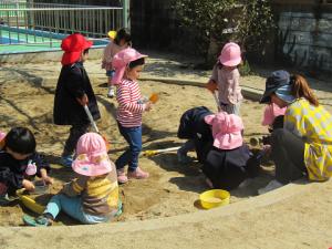 ３歳児が砂場で遊んでいます