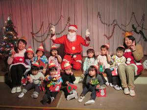 サンタさんと　一緒に写真を撮る２歳児