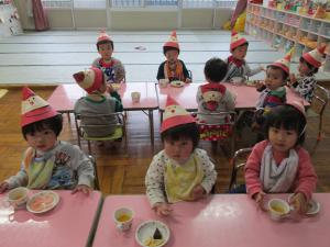 お部屋でおやつパーティーを楽しむ１歳児