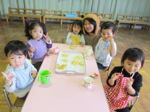 大きい組さんと一緒におやつパーティーを楽しむ２歳児