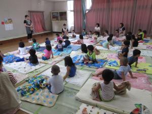 保育士の話を真剣に聞いている子供たちの様子
