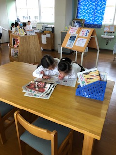 竹島小で新聞を熱心に読む児童の写真