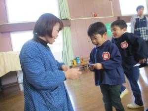 園長先生からお年玉をもらっている３歳児