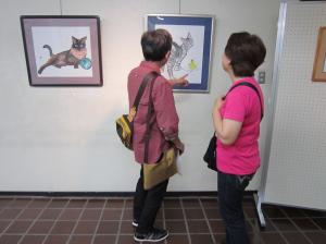 作品を見ている内藤勲さん（似顔絵師）です。