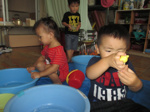 凍らせた容器を握っている二歳児