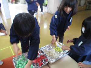 子どもたちが蒸しあがった団子を見たり、手に取ったりしている様子