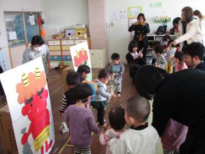 鬼の絵に向かって豆を投げる０．１歳児