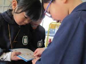 見つけたシールを台紙に貼る子ども①