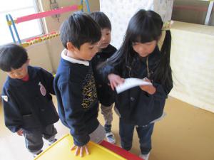 見つけたシールを台紙に貼る子ども②