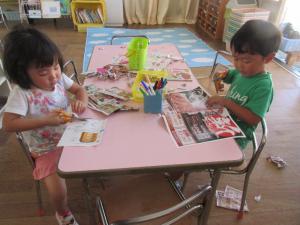 折り紙や広告をハサミで切る３歳児