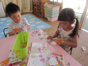 折り紙や広告で作っている３歳児