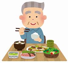 背筋を伸ばして椅子に座り食事を食べるおじいさん