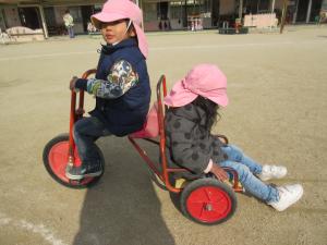 ２歳児が三輪車に乗っている画像