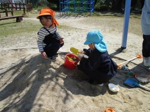 3歳児が砂場で遊んでいる画像