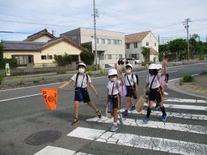 班長は旗を使い、手を挙げて渡ります