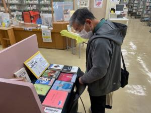 この写真は一般室のミニ特集を見ている内藤勲さんです。