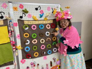 この写真はおはなしおばさんがドーナツを指さしているところです。