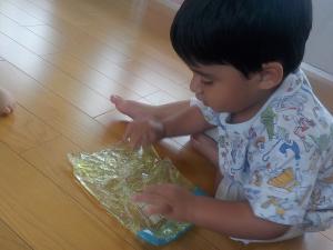 手でスライムを触る１歳児