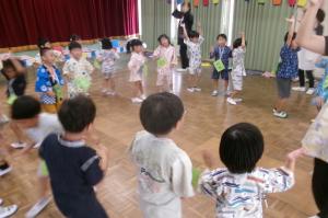 丸くなり盆踊りをする子どもたち