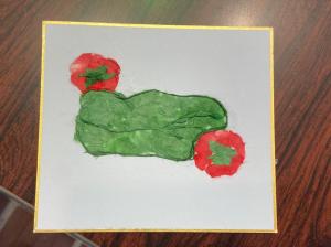 この写真はピーマンとミニトマトの和紙ちぎり絵作品です。
