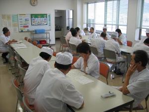 調理員全員で今日の調理作業の反省と翌日の打合せをしている写真です。