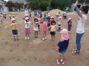 芝生で体操する子ども達