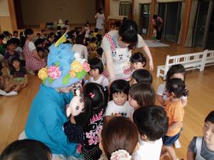 寝ぶたくんと子ども達が握手をしている写真です。