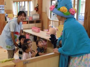 寝豚君と子ども達が握手をしている写真です。