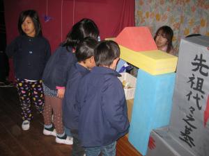 お墓の前でお参りをしています