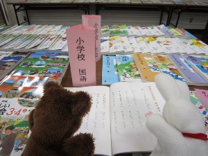 小学校教科書を読んでいるうさぎとくまです。